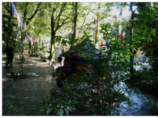 Les drapeaux de prières flottent au dessus d'un petit sanctuaire entouré de pierres à mani, à l'arrière, un four dans lequel brûle des feuilles de genévrier pour l’offrande de fumée aux Dieux.