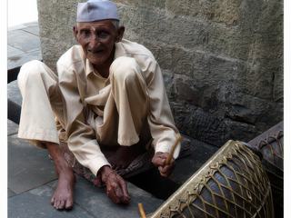 Musicien au temple de Baijnath, son instrument à percussion est composé d'une peau de chèvre tendue sur le fût et maintenue par des lanières de peau.