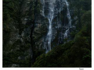 Une jolie cascade dévale et vient se jeter dans une rivière.