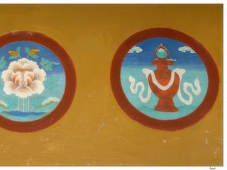 Quatre des huit signes auspicieux du bouddhisme tibétain, de gauche à droite: - le noeud sans fin représente l'esprit du Bouddha ainsi que l'interdépendance de toutes choses, l'union de la compassion et de la sagesse, de la sagesse et des moyens, ou du vide et de l'interdépendance. Il représente aussi le samsara, le monde de la souffrance où on nait et meurt en boucle. - la conque symbolise le son du Dharma profond qui éveille les êtres du sommeil de l'ignorance et les incite à accomplir leur propre bien ainsi que celui des autres êtres. - le lotus symbolise la purification du corps, de la parole et de l'esprit, ainsi que le plein épanouissement de l'activité bénéfique dans l'état de libération. Il est l'emblème de l'élévation spirituelle. - le vase représente une pluie sans fin de longue vie, de richesses, de prospérité, de tout ce qui est bon pour les hommes dans le domaine temporel et spirituel. Son embouchure est surmontée d'un joyau flamboyant.