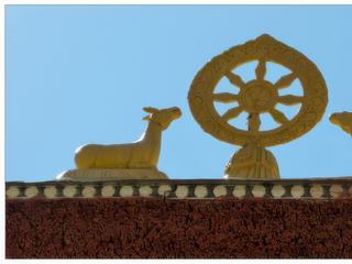 La roue du Dharma, l'un des huit signes auspicieux, entourée de deux daims.