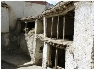 Nous passons à travers des ruelles étroites devant des maisons anciennes et des bâtiments où sont entassées des récoltes de bois et de céréales.