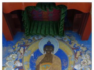 Dans les monastères, le Bouddha est représenté dans différentes postures. Ici, il est dans celle appelée "posture Bhumisparsa", geste de la prise de la terre à témoin. Dans sa dernière méditation avant l'éveil, le Bouddha subit les attaques de Mara, personnification du mal, qui tenta divers stratagèmes pour interrompre sa méditation. Finalement, Mara nia la réalité de l'éveil du Bouddha, arguant qu'il n'y avait pas de témoin; celui-ci toucha alors la terre (Bhumi ou Prithvi), qui était son témoin. A droite, Sariputta (Sariputra), son premier disciple, à gauche, Mogallana (Maudgalyayana), second disciple en titre; tous deux seraient morts quelques mois avant le Bouddha.