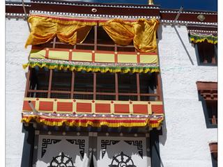 Il arrive que, devant la façade du temple, soit tendue une grande pièce de tissu blanche aux motifs noirs. Ici, il s'agit de la roue du Dharma (roue de la vie).