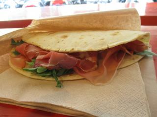 Spécialité de Bologne: la piadina, un genre de galette pliée en deux contenant fromage, charcuterie, crudités...