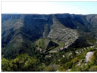 Mieux vaut être prudent sur la route! Dans un virage nous découvrons le Rocher de la Vierge et Navacelles, village blotti au fond d'un canyon. D’une profondeur de 300 mètres, il s’agit plus spécifiquement d’un méandre abandonné par la Vis, qui s’est ouvert un nouveau cours plus direct, en créant une cascade de plus de 8 mètres de haut.