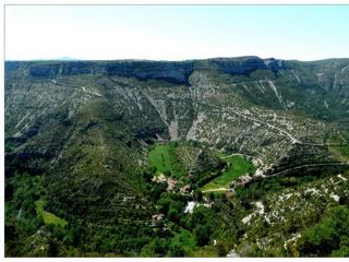 Au centre du cirque, le Rocher de la Vierge, ou plus familièrement "l’huître", est entouré d’une bande de terre très fertile: c’est l’ancien lit de la rivière. Ses prairies verdoyantes, la cascade et la ripisylve boisée (végétation bordant les milieux aquatiques), offrent un contraste saisissant avec les versants abrupts, arides et caillouteux des gorges. Imaginez le travail formidable de la Nature en sachant que c'est la rivière, la Vis, qui a creusé ce canyon au rythme d'1/10e de millimètres par an! Au XIe siècle, les humains se sont installés au fond du cirque. Des moines ont édifié une abbaye et cultivé les terres fertiles de l'ancien lit de la rivière. En 1874, une chapelle fut édifiée en lieu et place de l'abbaye dont il ne reste plus trace.