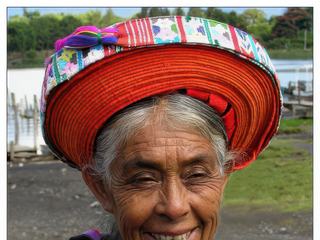 Jolie rencontre au débarcadère de Panajachel. Cette coiffe (toyocal) est un long ruban de tissu rouge enroulé autour de la tête de cette indienne. Selon la façon dont il est porté, il indique si la femme qui le porte est célibataire ou mariée.