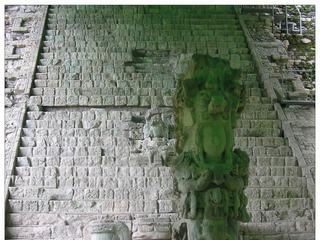 En bas de l'escalier, la stèle M (756 apr.J.C.) représente K'ak 'Yipyaj Chan K'awiil (Fumée-Coquillage), 15ème souverain de Copán. Elle est relativement abimée en raison d'une chute. La bâche verte lui donne malheureusement cet aspect verdâtre. On devine qu'elle a dû être très belle.