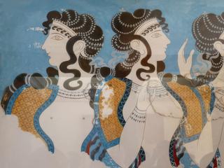 Détail de la fresque "Les dames en bleu'. Composition de personnages féminins richement vêtus et somptueusement parés de bijoux sur fond bleu. Malgré son état fragmentaire, l'oeuvre montre l'opulence et la prospérite de la cour royale a cette époque. Reconstitution effectuée par A. Evans avec des fragments de l'oeuvre originale retrouvés sur le site de Knossos. 1600-1450 av J.-C. L'original est au musee archéologique d'Heraklion.