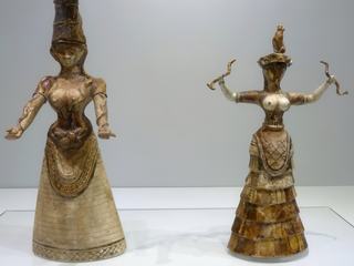Ces deux statuettes en faïence font partie du must du musée. Elles datent de 1600 av J.-C et ont été retrouvées en 1903 à Knossos, dans deux grands coffres à parois de pierre, certainement déposés après la destruction d’un sanctuaire, d’où le nom donné à cet espace par Arthur Evans, "Temple repositories" (dépôt du sanctuaire). On les appelle "les déesses aux serpents". Evans a interprété la plus grande, coiffée d’une haute tiare, comme une déesse, tandis que la plus petite, dont le visage est manquant et a été reconstitué par Gilliéron, serait une prêtresse. D’autres y voient une déesse mère et sa fille ou encore deux charmeuses de serpents intervenant lors de cérémonies religieuses! Ces serpents tenus à bout de mains, symboles du monde souterrain mais également de fertilité, pourraient avoir fait l’objet d’un culte particulier en Crète.