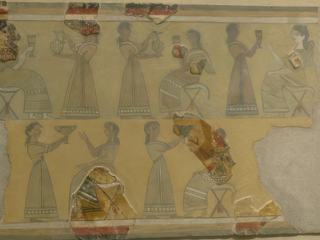 Cette fresque exceptionnelle a été réalisée peu avant la destruction du palais de Knossos, entre 1400 et 1350 av J.-C. En la découvrant, les archéologues l'ont appelée "la Parisienne", à cause du maquillage que porte le 3ème personnage assis. Sans doute une prêtresse qui prend part à un banquet rituel.