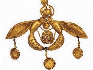 Ce bijou en or, appelé "le pendentif aux abeilles" (1800-1700 av J.-C), a été trouvé dans la nécropole de Malia, lors de la campagne de fouilles de 1930. Malheureusement la tombe avait été pillée. Il représente deux abeilles, dont les têtes et les extrémités de l'abdomen se rejoignent pour former un cercle fermé. Elles tiennent entre leurs pattes un rayon de miel et y déposent une goutte de miel. Une petite cage sphérique enfermant entre ses barreaux une bille en or est posée sur leur tête. Les trois pendeloques suspendues aux ailes et à la jointure des abdomens viennent compléter ce bijou remarquable et lui donner son équilibre. C’est l’un des plus beaux chefs-d’œuvre minoens. Il est exposé au Musée archéologique d'Héraklion, mais je ne l'avais pas photographié, il s'agit de la photographie d'un livre.
