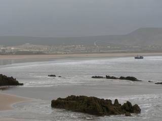 Des pêcheurs ramènent leurs bateau sur la plage.