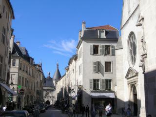 Grande Rue avec la Porte de la Craffe au fond, à droite la façade de l'Eglise des Cordeliers et une gargouille du Palais Ducal.